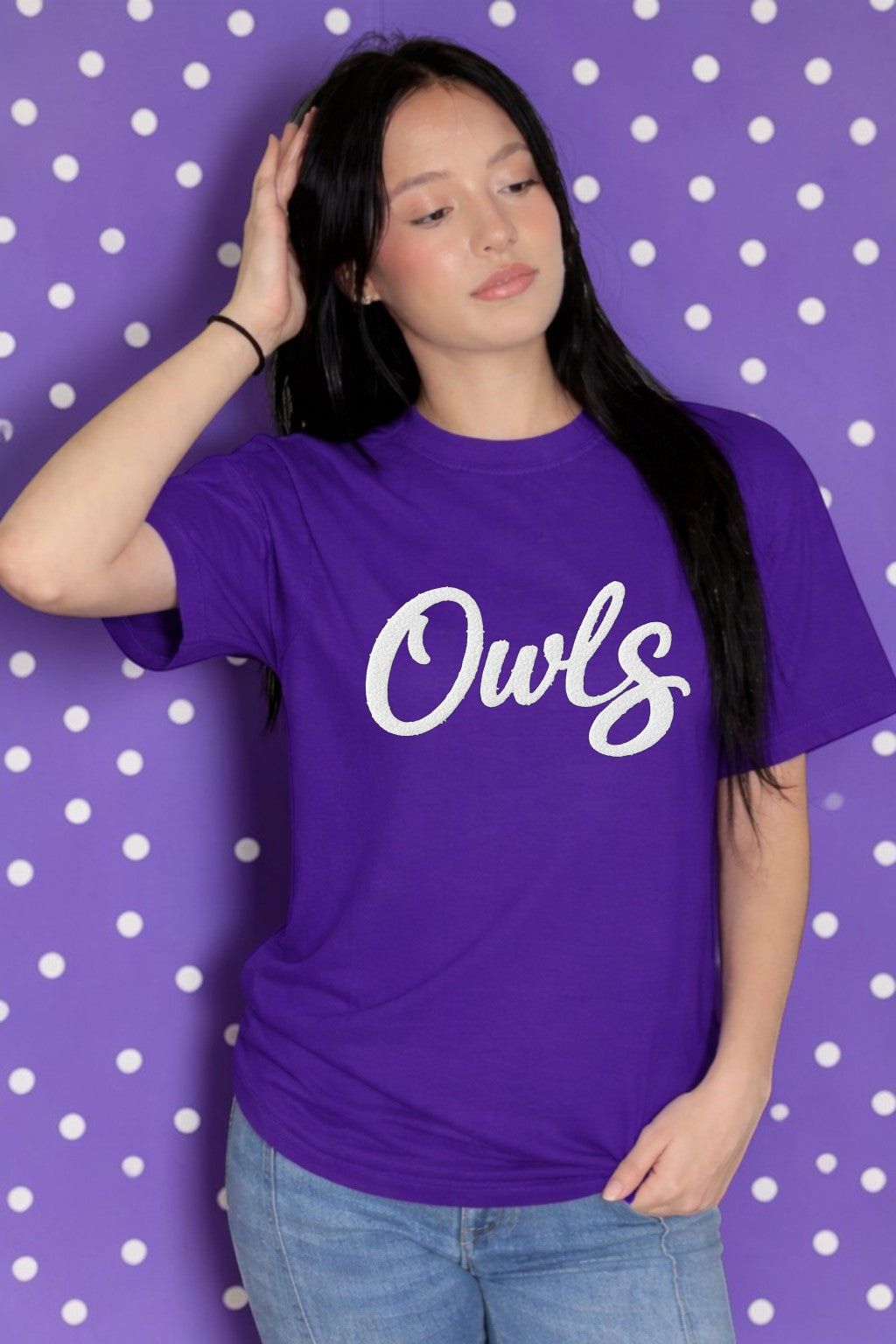 Person wearing a purple t-shirt with 'Owls' text against a polka dot background