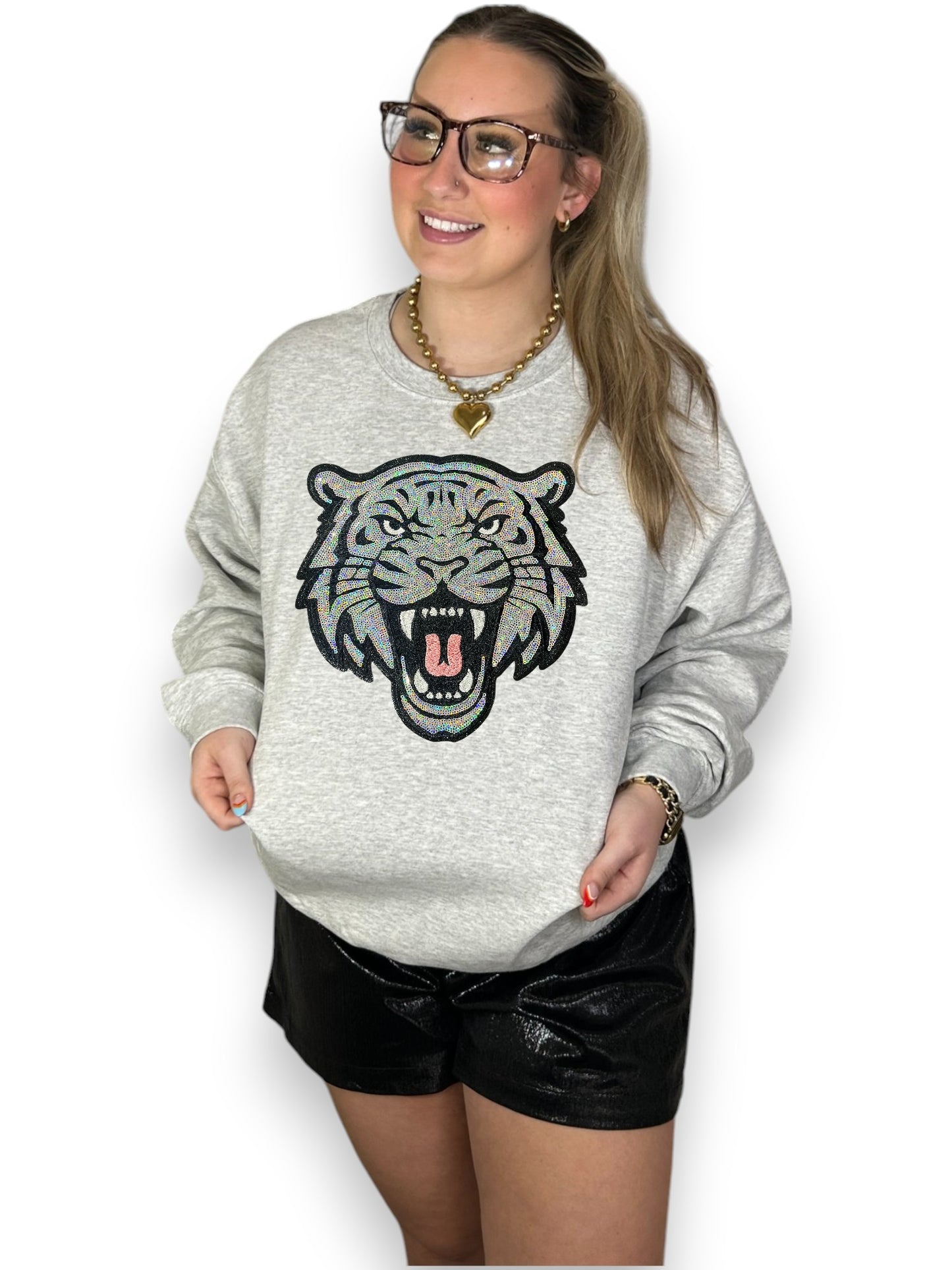 Person wearing a gray sweatshirt with a tiger graphic design on a white background