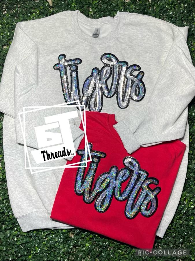 cursive sequin tigers patch on gray sweatshirt and red shirt