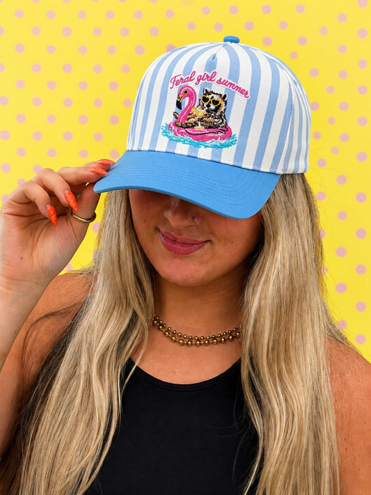 Person wearing a blue and white striped cap with a graphic design on a yellow polka dot background