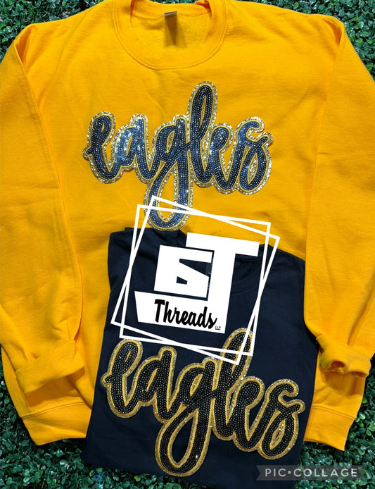 black and gold cursive sequin eagles patch on gold sweatshirt and black shirt