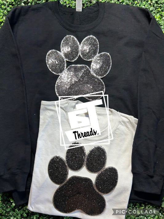 black sequin paw print patch on black sweatshirt and white shirt