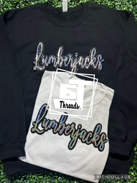 cursive sequin lumberjacks patch on black sweatshirt and white shirt