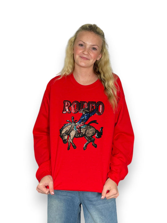 Person wearing a red sweatshirt with a graphic design on a white background