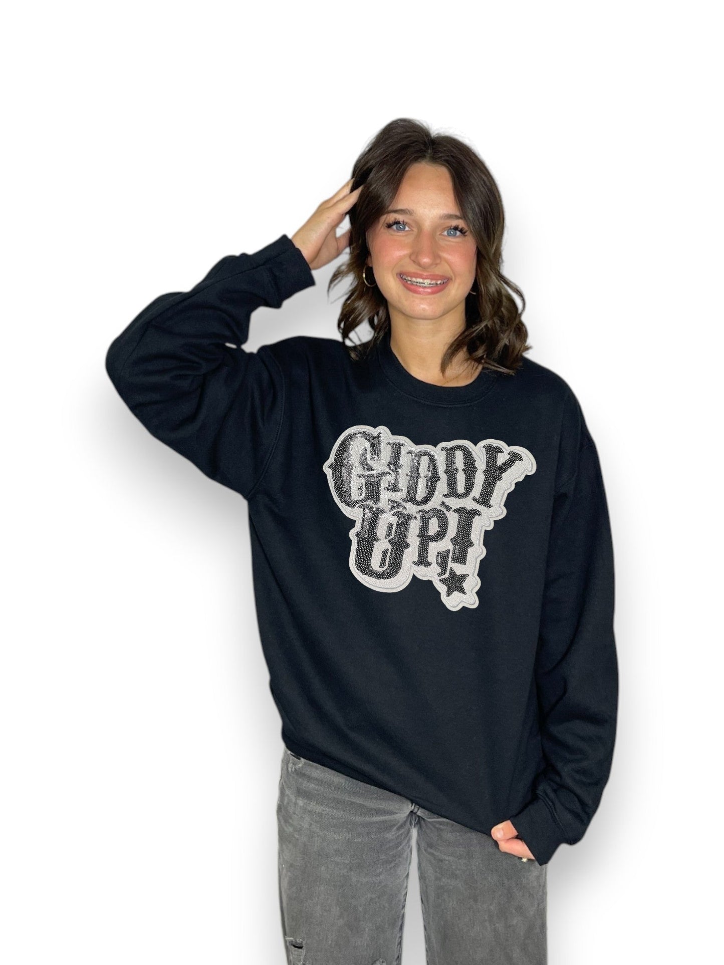 Person wearing a navy blue sweatshirt with 'Giddy Up!' text on a white background