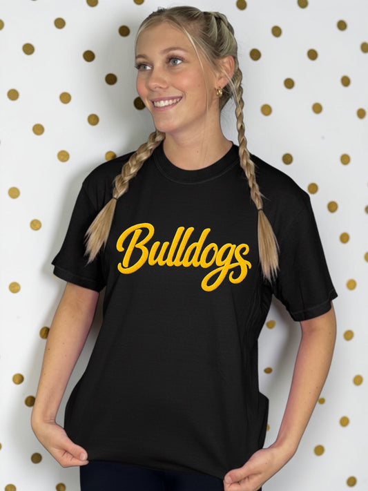 Person wearing a black t-shirt with 'Bulldogs' in yellow text against a polka dot background