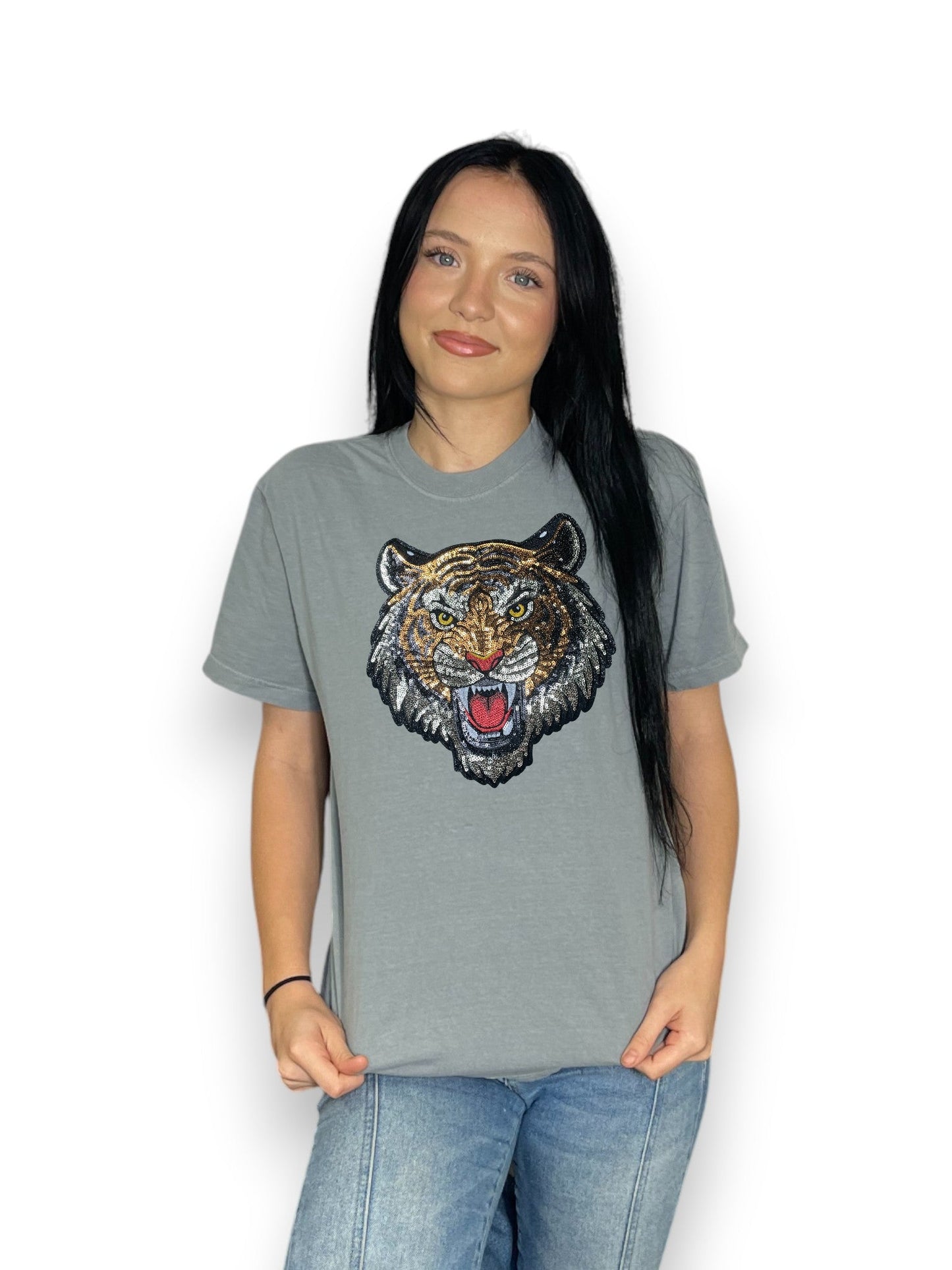 Person wearing a gray t-shirt with a tiger graphic on a white background