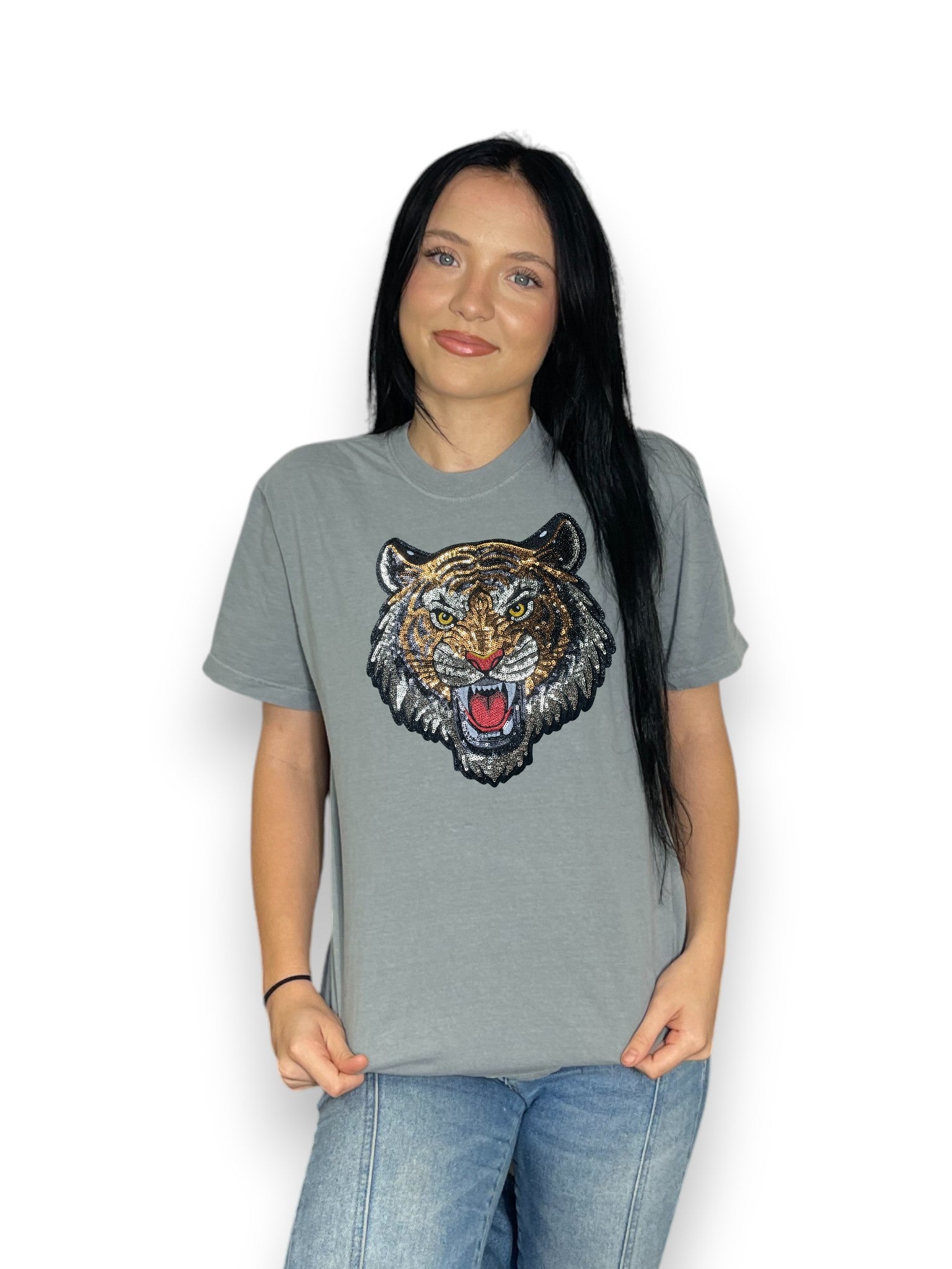 Person wearing a gray t-shirt with a tiger graphic on a white background