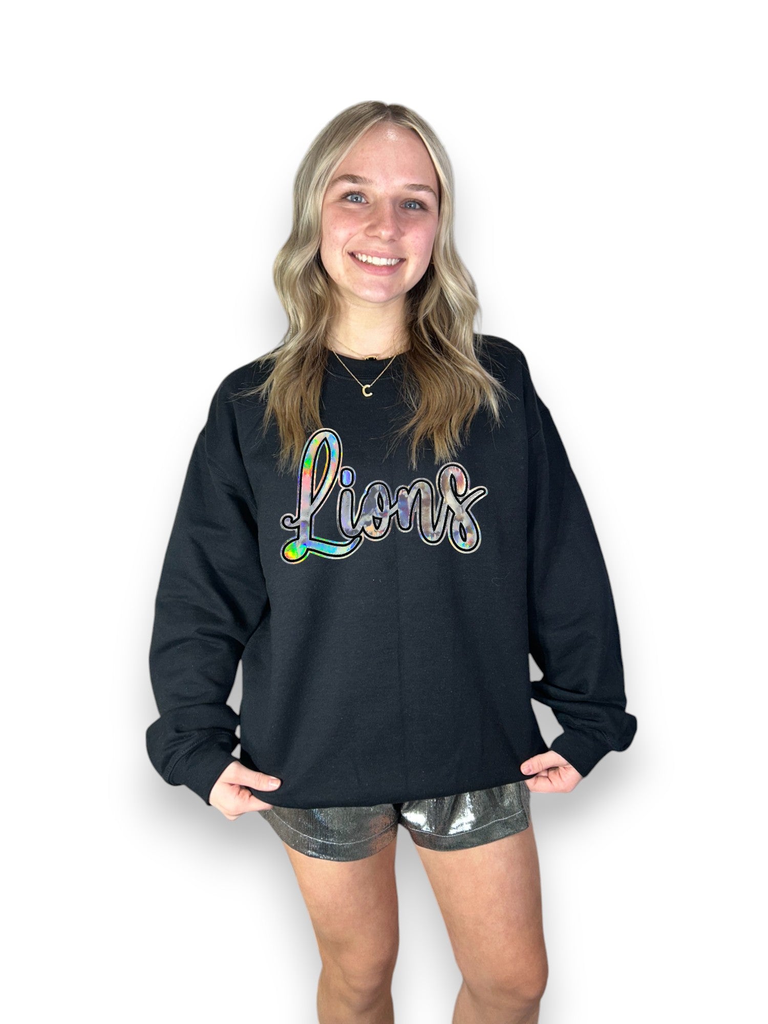 Silver Cursive Metallic Lions patch on black sweatshirt